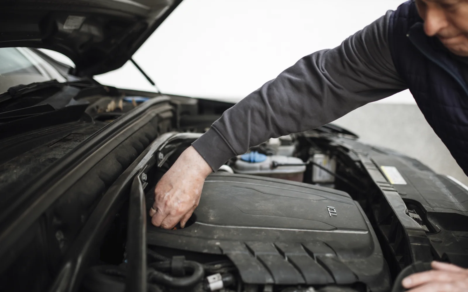 Evaluator verificând motorul unei mașini